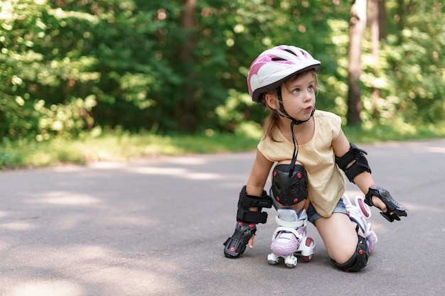 ローラースケートを学ぶかわいい子供の女の子