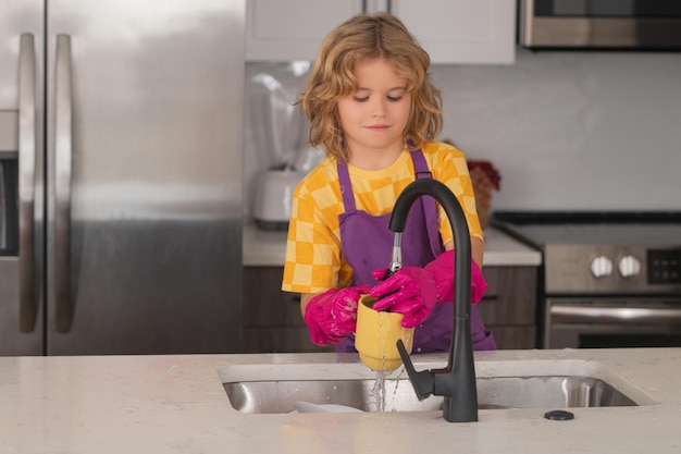 Cute kid help in washing dishes at kitchen kid cleaning of kithen help with housework cute child boy