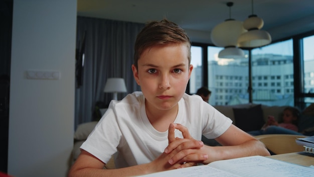 Cute kid nodding head during online lesson Clever boy looking camera indoors