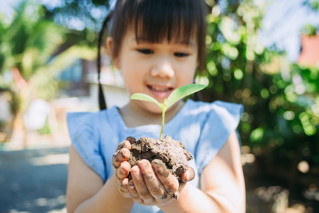 Cute kid planting a tree for help to prevent global warming or climate change and save the earth
