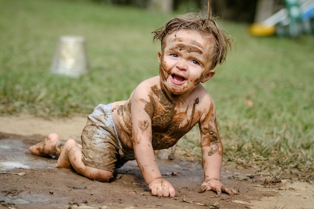 Фото Милый ребенок играет в грязи с ведром