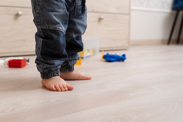 Foto piedi di bambino carino in piedi nel soggiorno