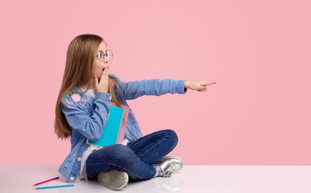 Cute kid in trendy outfit thinking doing homework