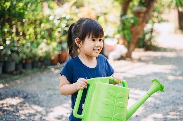 木に水をまくかわいい子供。