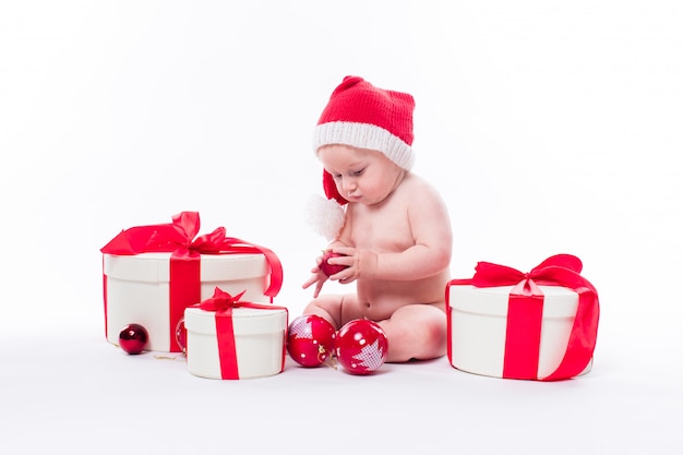 Cute kid with christmas gifts and santa claus hat