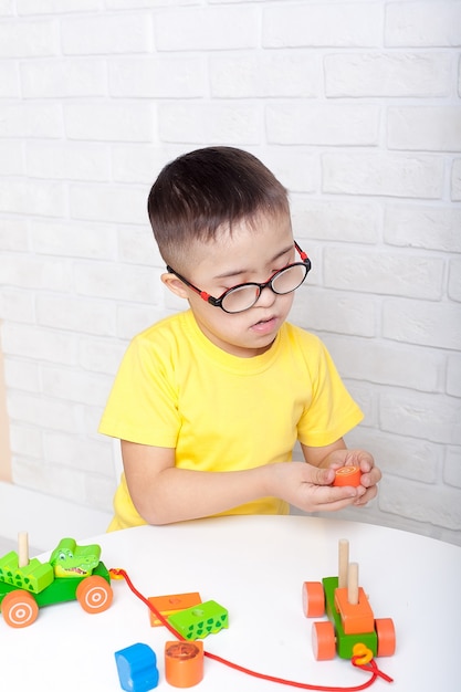 cute kid with down's syndrome playing in kindergarten.