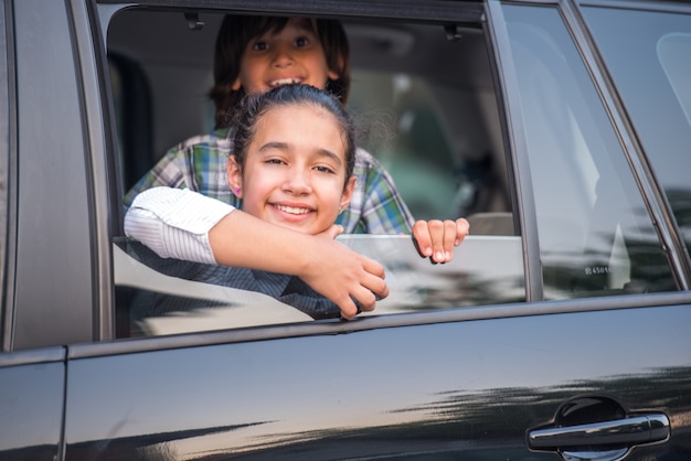 Cute kids looking through car window