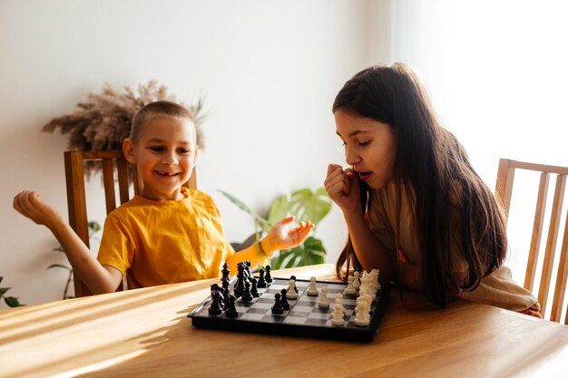 Photo cute kids playing chess at home