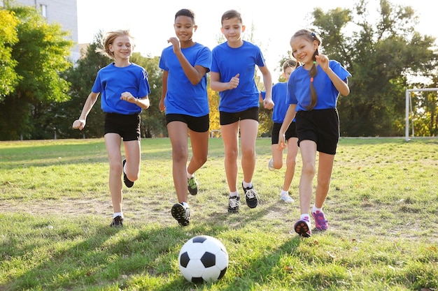 Foto bambini carini che giocano a calcio sul campo