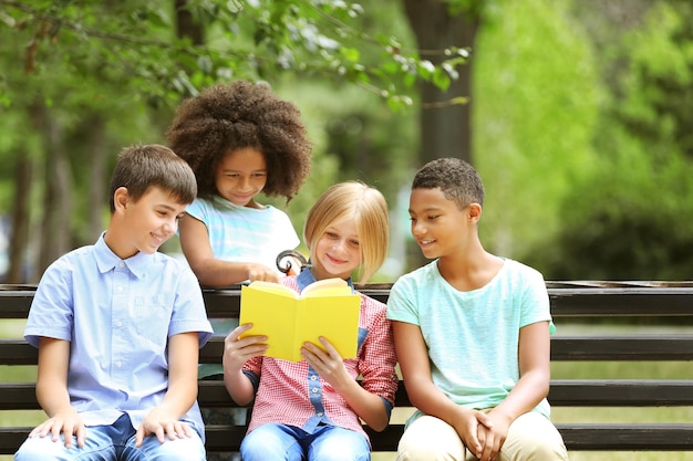 Photo cute kids reading book on bench