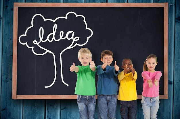 cute kids showing thumbs up against blackboard on wooden board