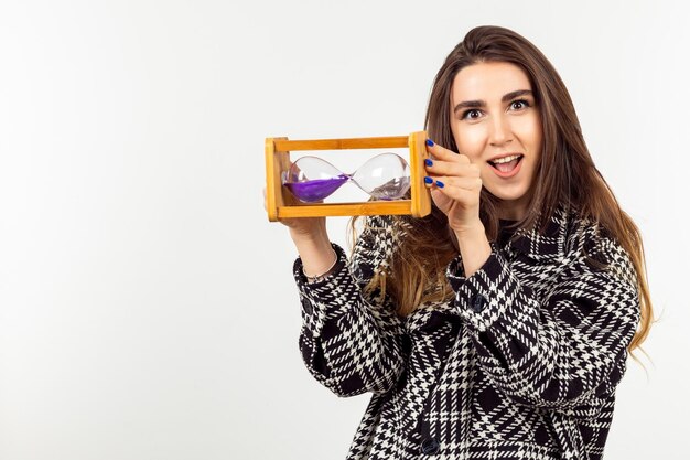 A cute lady holding hourglass and stand on white background