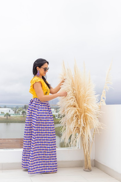 Cute Latin woman enjoys arranging her pampas grass flower arrangement