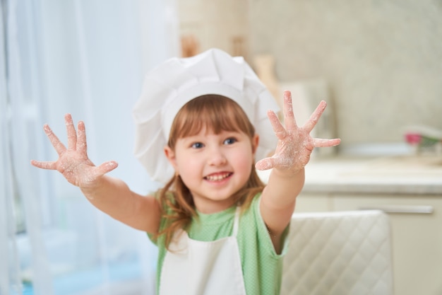 Cute laughing baby cook waving his hands