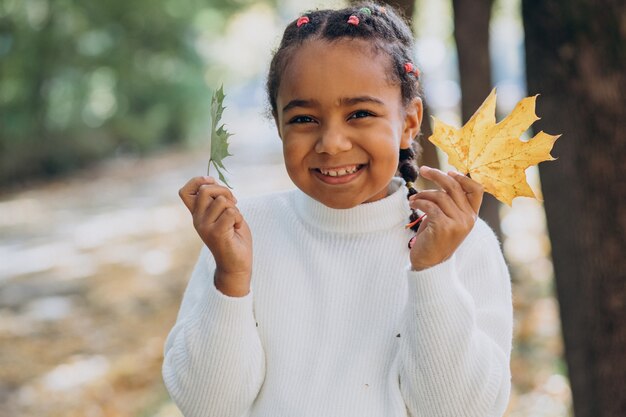 Cute little african girl in autumnal park