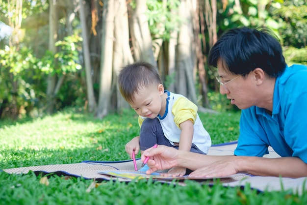 Милый маленький азиат 2 - 3 лет малыш мальчик рисует мелками