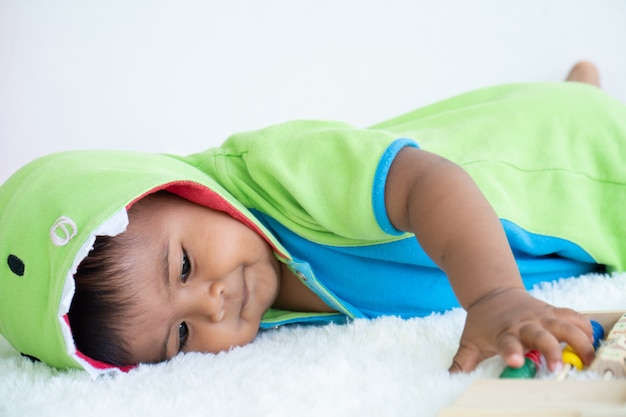 横になっているおもちゃを遊ぶかわいいアジアの男の子