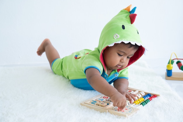 Cute little asian baby boy lying and play toy 