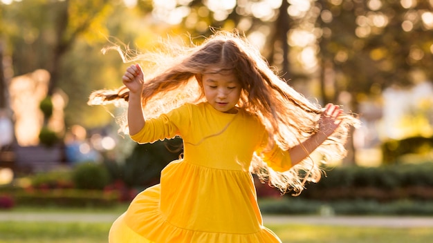 Photo cute little asian girl having fun outdoors