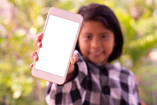 白い空白の画面とスマートフォンを示すかわいいアジア人少女