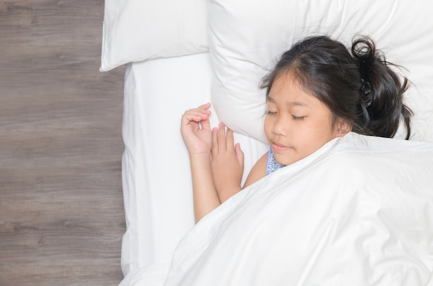 Cute little asian girl sleep on bed in the bedroom.