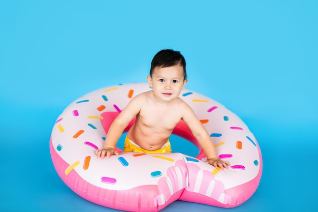 Cute little baby boy in inflated rubber ring 