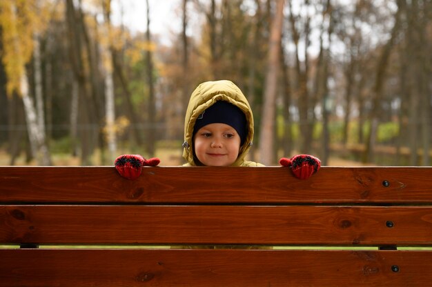 Il piccolo neonato sveglio si diverte nel parco d'autunno con la sua famiglia in una soleggiata giornata autunnale