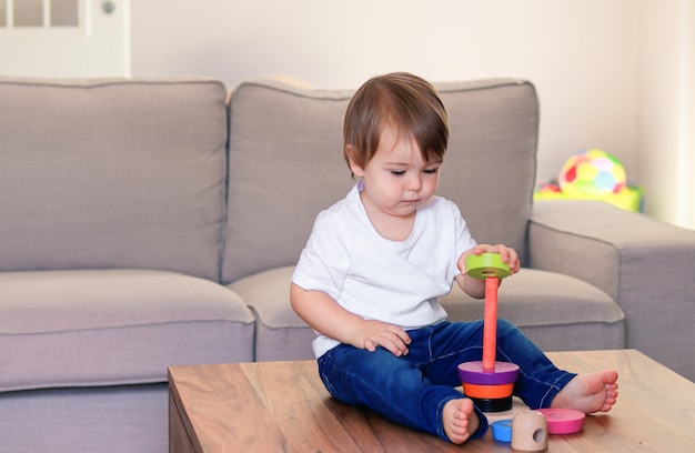 写真 カラフルな木製のピラミッドを自宅で遊ぶかわいい男の子。