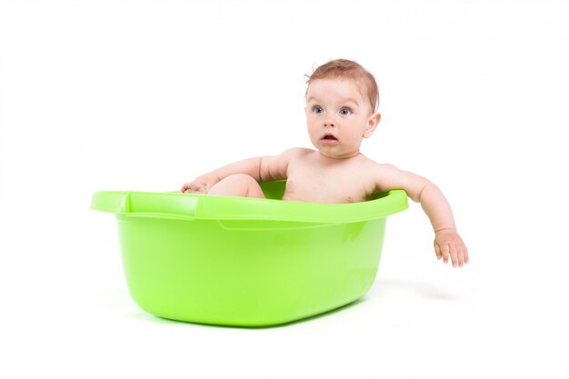 cute little baby boy take bath in green tub