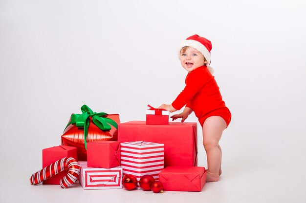 Cute little baby in a Christmas costume with gifts