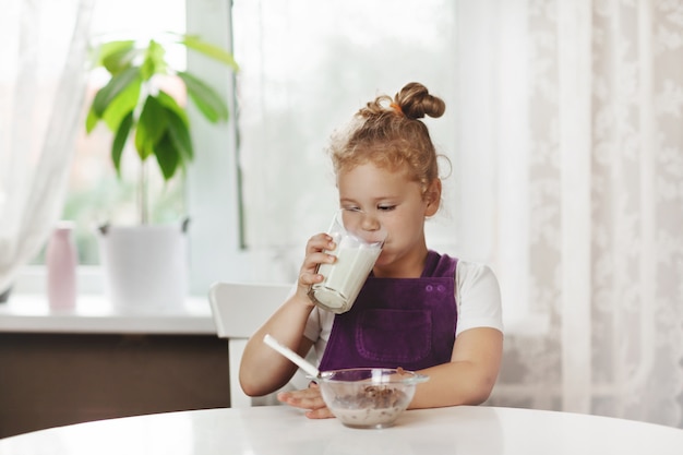 Foto piccola neonata sveglia che mangia prima colazione