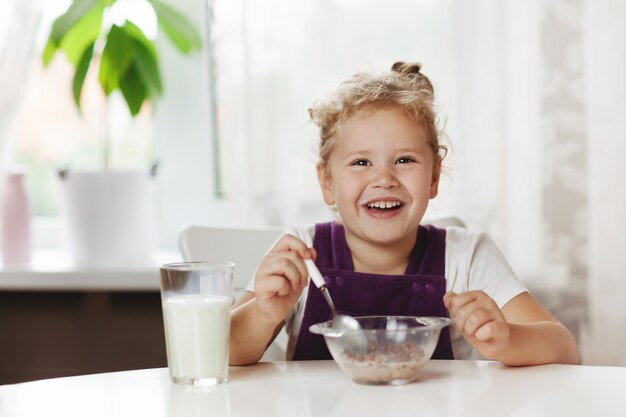 Foto piccola neonata sveglia che mangia prima colazione