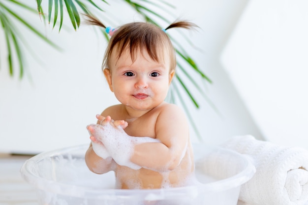 Piccola neonata sveglia che cattura un bagno