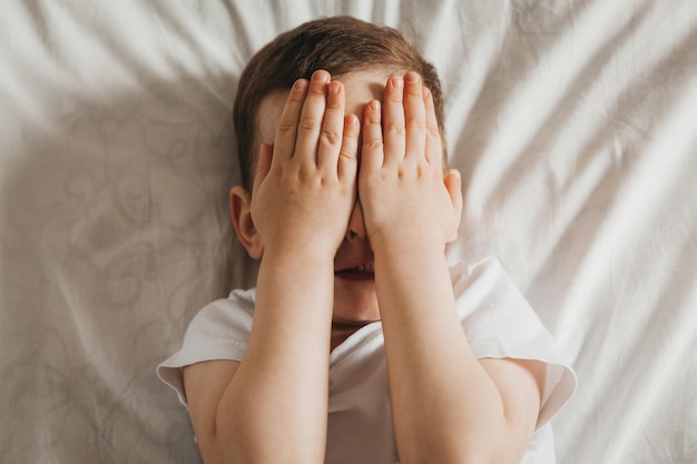 Cute little baby lies on the bed top view portrait of a boy in bed