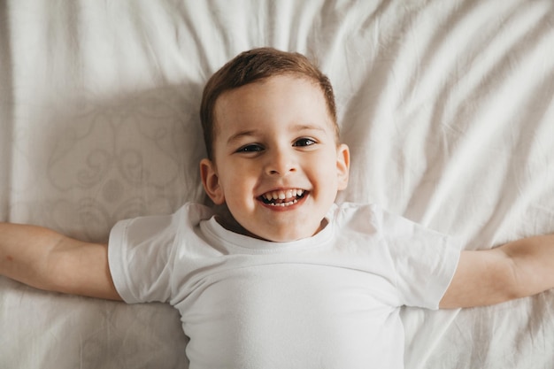 Cute little baby lies on the bed top view portrait of a boy in bed