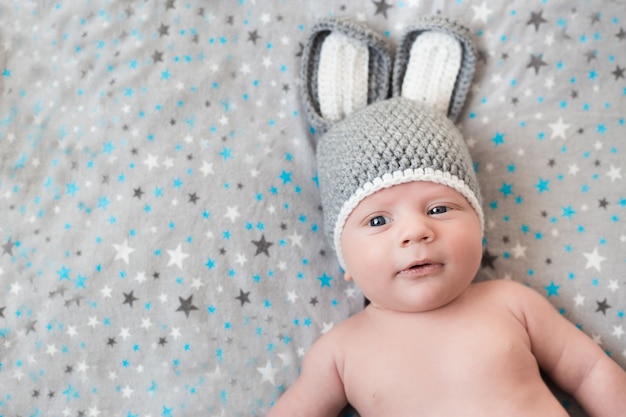 Cute little baby lies in a hare costume on a white. newborn in a hat with ears on a white
