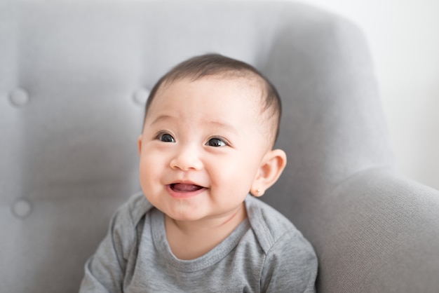 Cute little baby playing at home in gray room