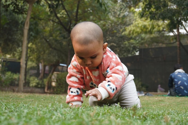 Photo cute little baby playing outside in the field