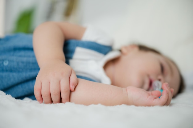 Cute little baby resting and sleeping with comfort at home on white bed