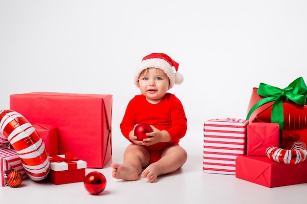 Cute little baby in a Santa costume with gifts