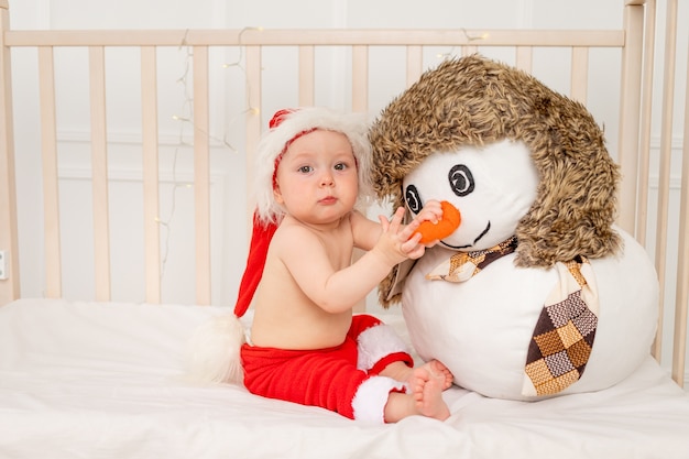 Piccolo bambino sveglio in costume di babbo natale