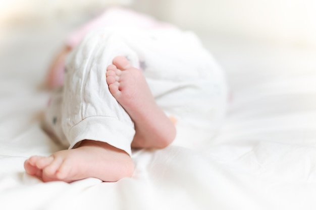 Piccolo bambino sveglio che dorme sul letto a casa piccoli piedi del bambino