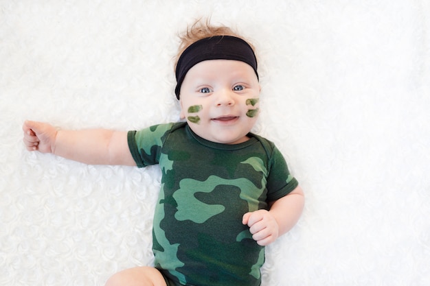 Cute little baby soldier in uniform. little boy in camouflage suit on a white