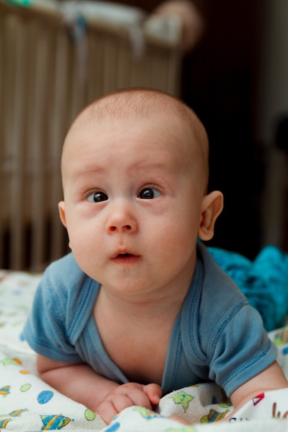 Cute little baby with strabismus in bed