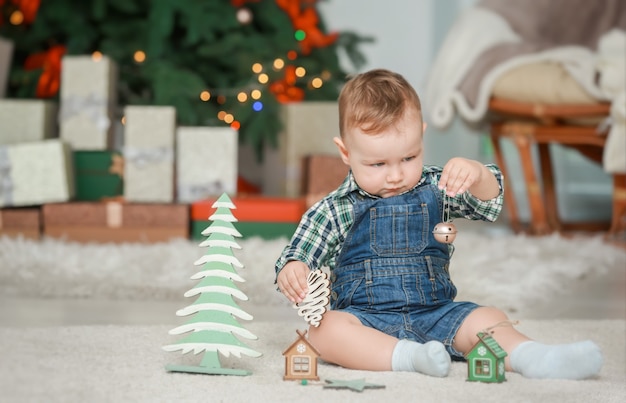 クリスマスのために飾られた部屋のおもちゃでかわいい赤ちゃん