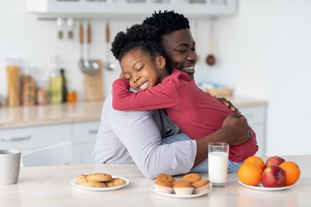 Cute little black girl embracing her father