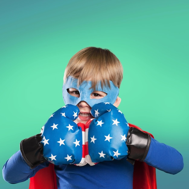 Photo cute little blond boy in superhero boxer gloves