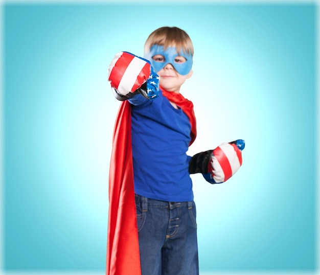 Cute little blond boy in superhero boxer gloves