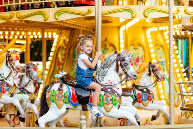 Cute little blonde girl in an amusement park