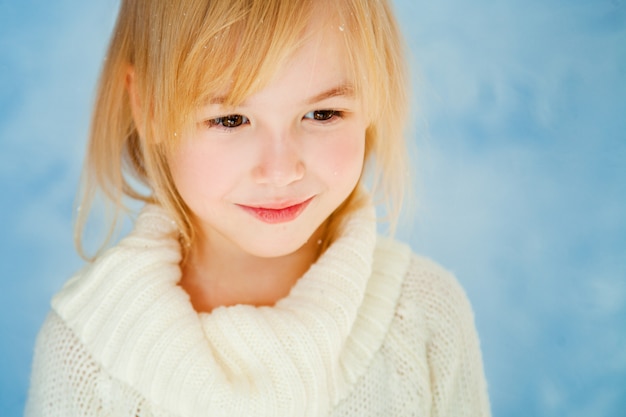 Cute little blonde girl on the blue background